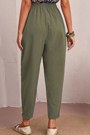 Person wearing olive green pants against a plain background