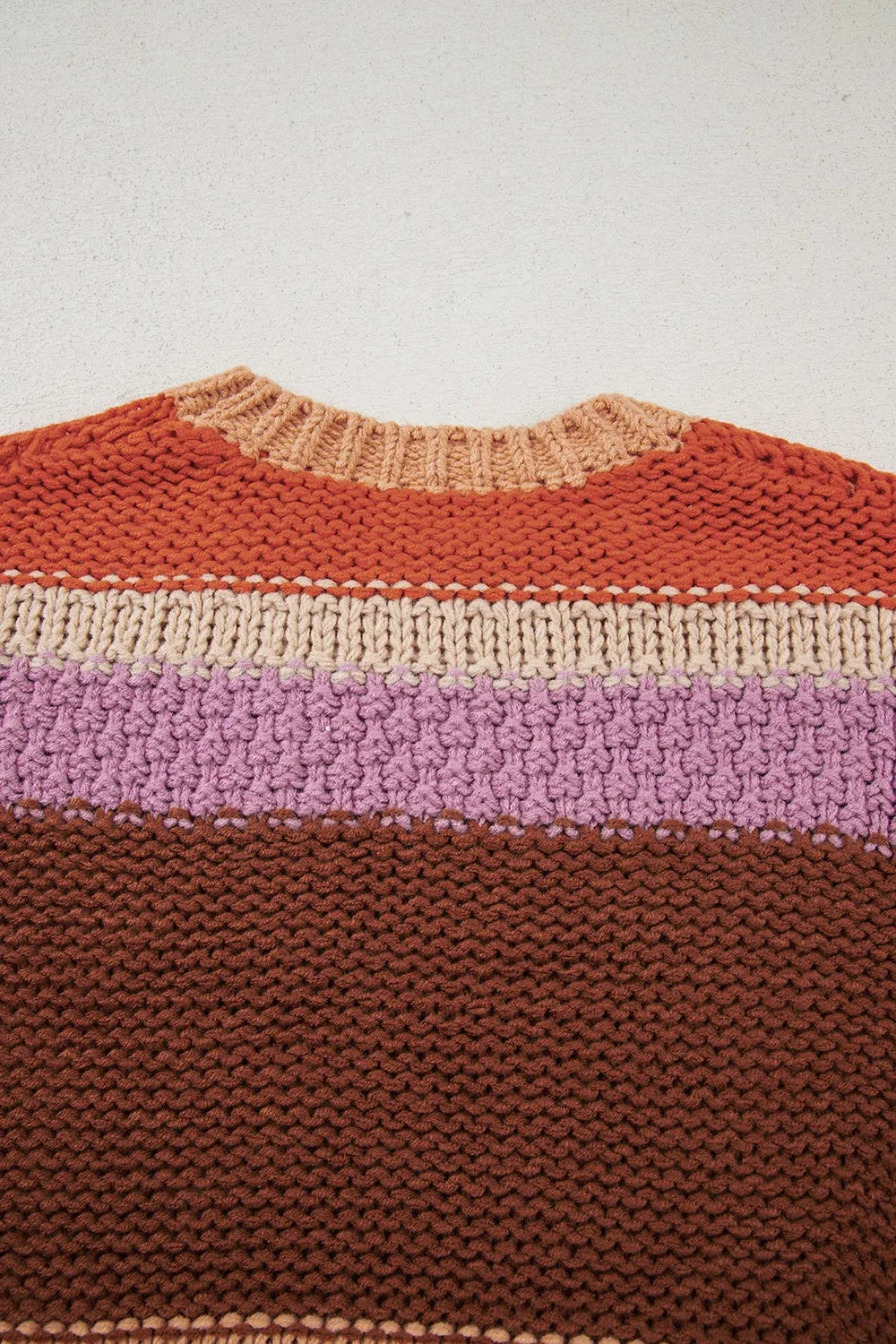 Close-up of a knitted sweater with horizontal color stripes on a light background