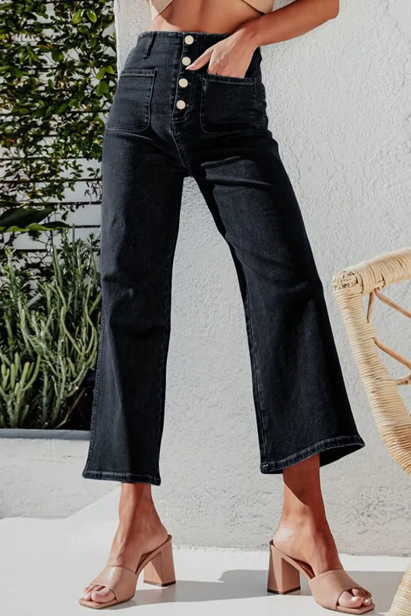 Person wearing dark blue jeans with a white background