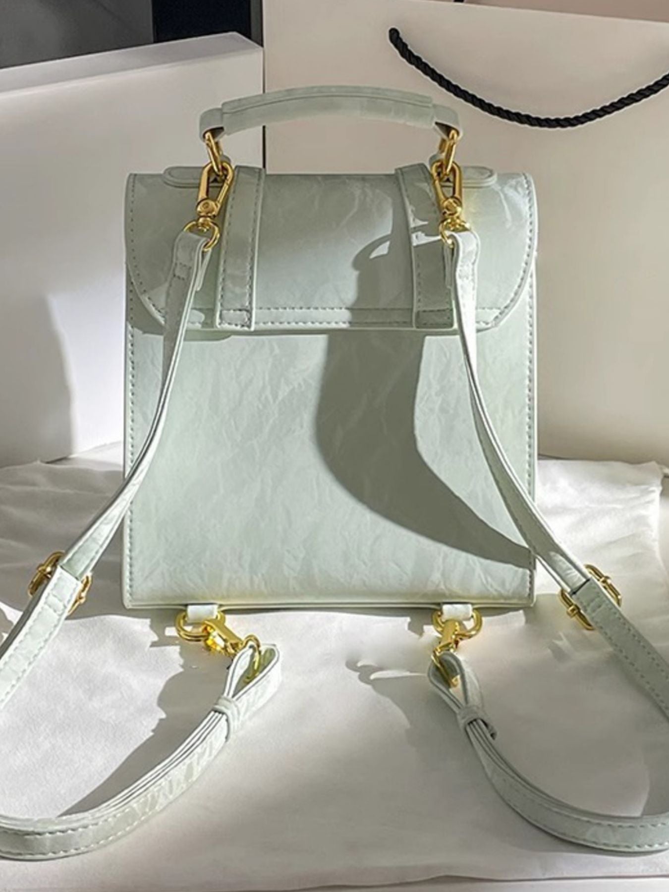 Light blue handbag with gold accents on a white surface