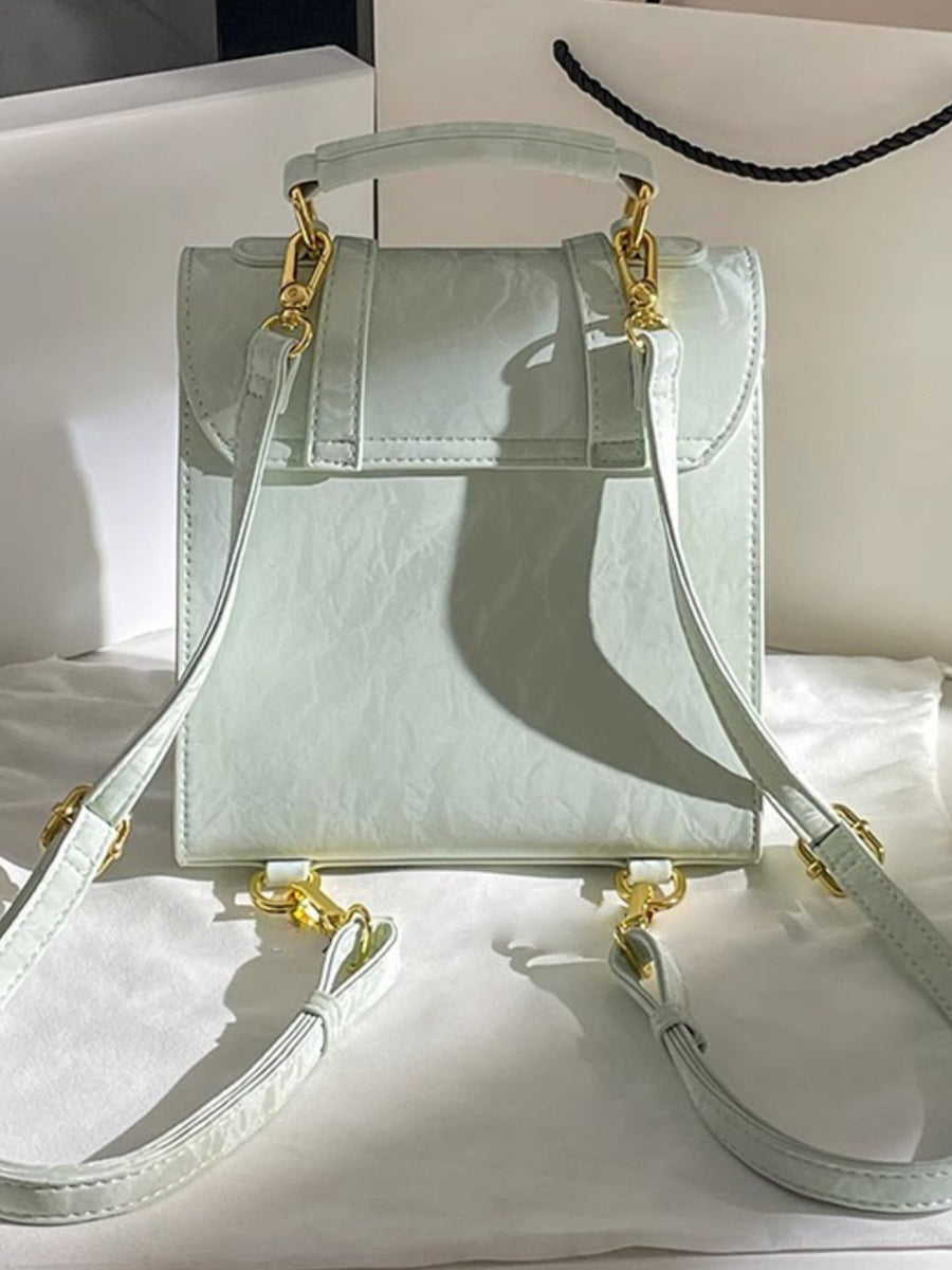 Light blue handbag with gold accents on a white surface