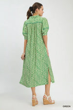 Woman wearing a green patterned dress on a white background