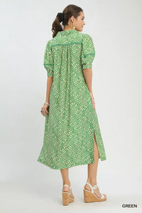 Woman wearing a green patterned dress on a white background