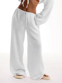 White lounge pants worn by a person on a white background