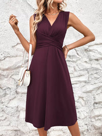 Woman wearing a purple dress against a textured stone wall.