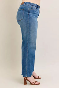 Blue jeans worn by a person on a beige background