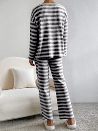 Person wearing a black and white striped outfit in a minimalistic room.