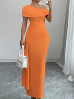 Woman wearing an orange off-shoulder dress holding a white handbag indoors.
