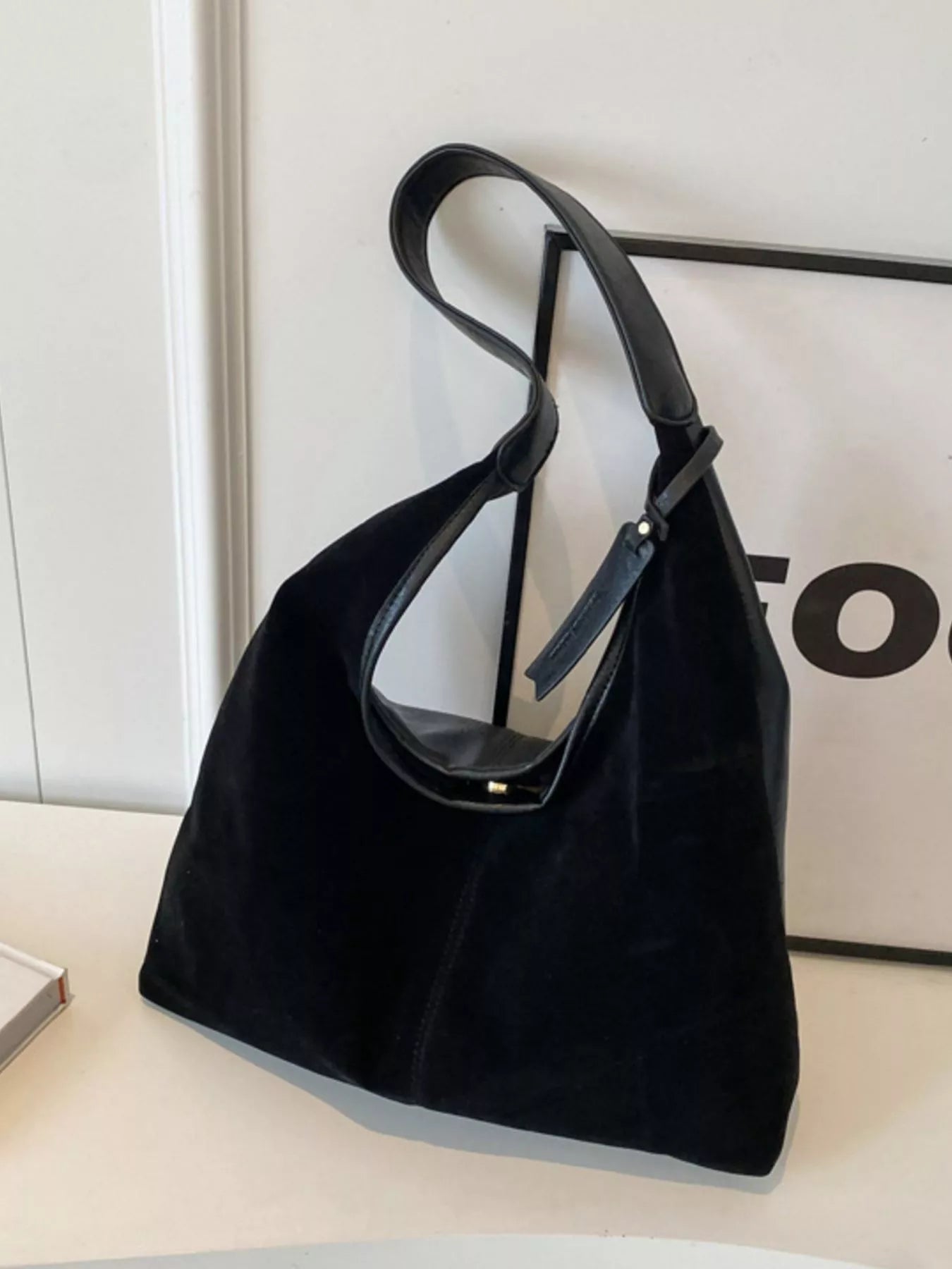 Black handbag on a light surface with a blurred background