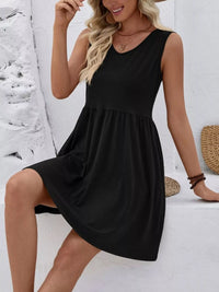 Woman wearing a black sleeveless dress against a white background