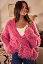 Woman wearing a pink fuzzy cardigan in a cozy indoor setting