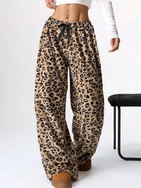 Leopard print pants worn by a person on a white background