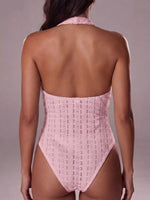 Pink lace bodysuit worn by a model on a plain background