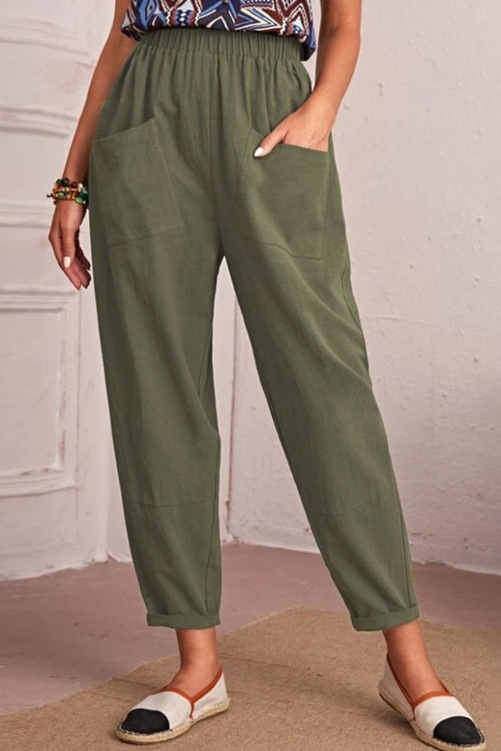 Person wearing green pants with a plain background