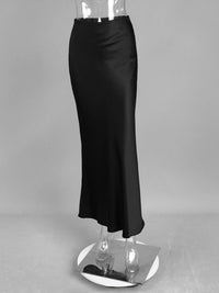 Black satin skirt on a mannequin against a gray background