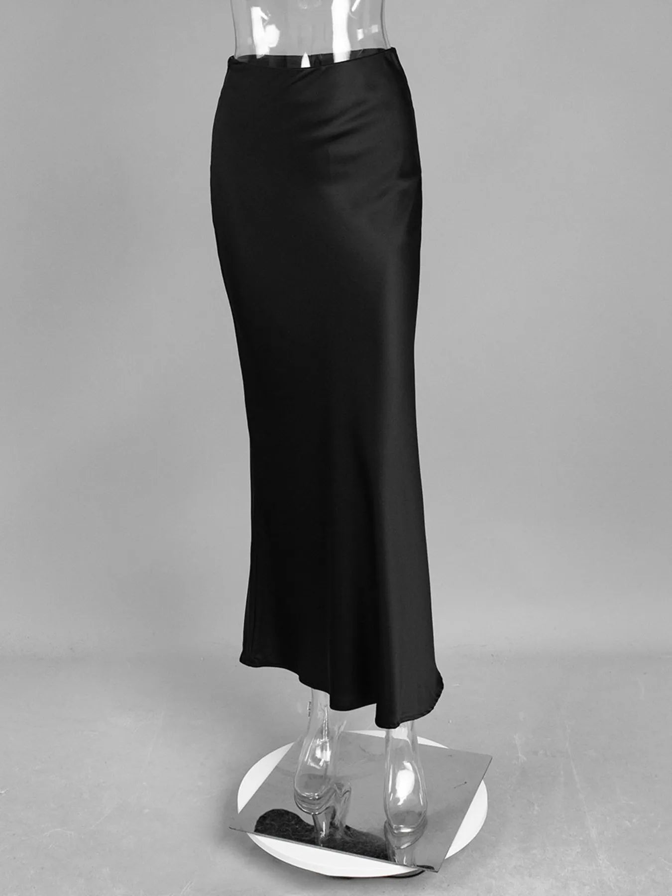 Black satin skirt on a mannequin against a gray background