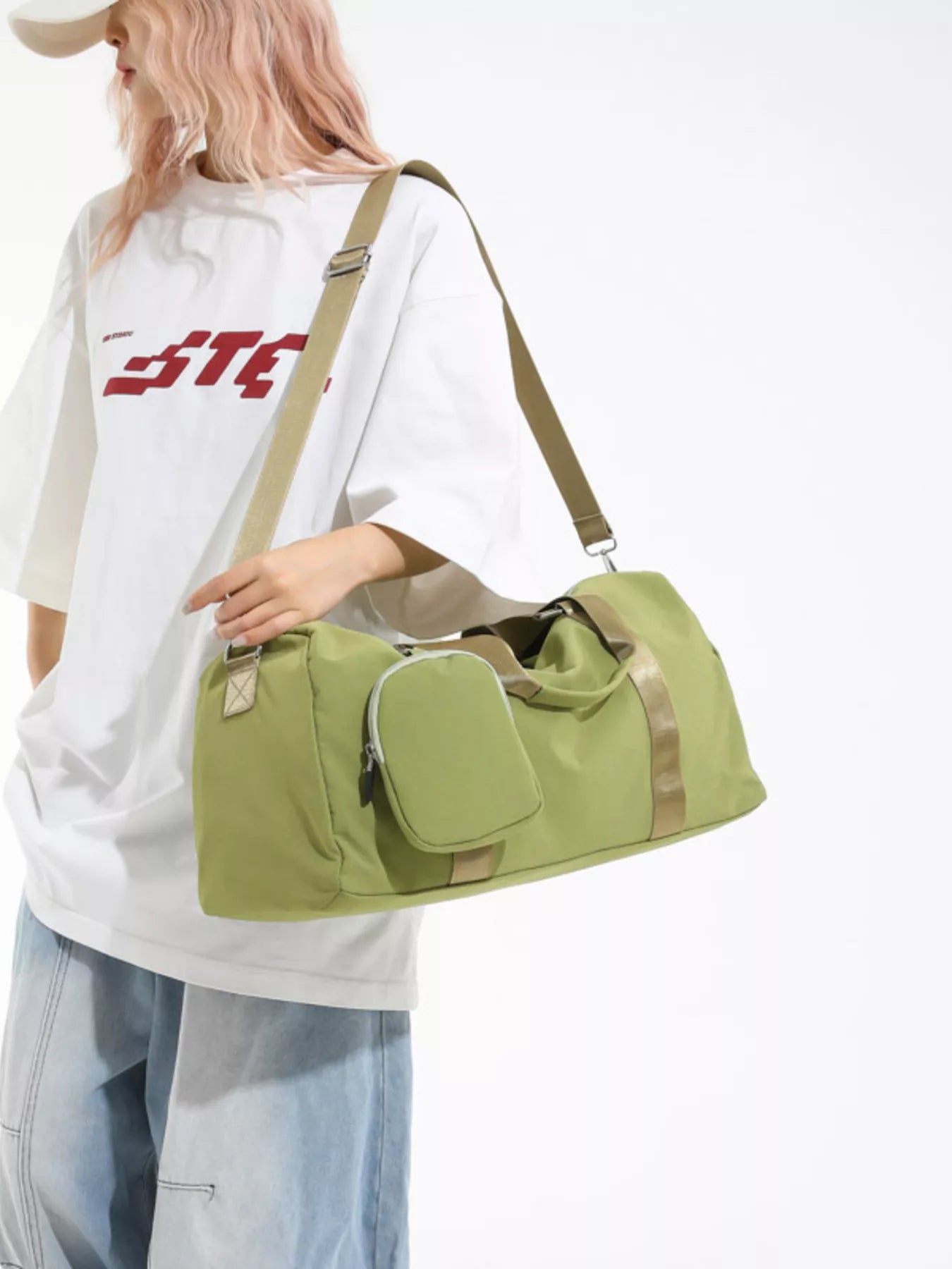 Person holding a green duffel bag with beige straps on a white background