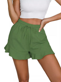 Green shorts worn by a person on a white background