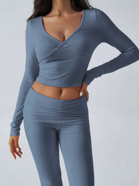 Person wearing a blue long-sleeve top and leggings set on a plain background