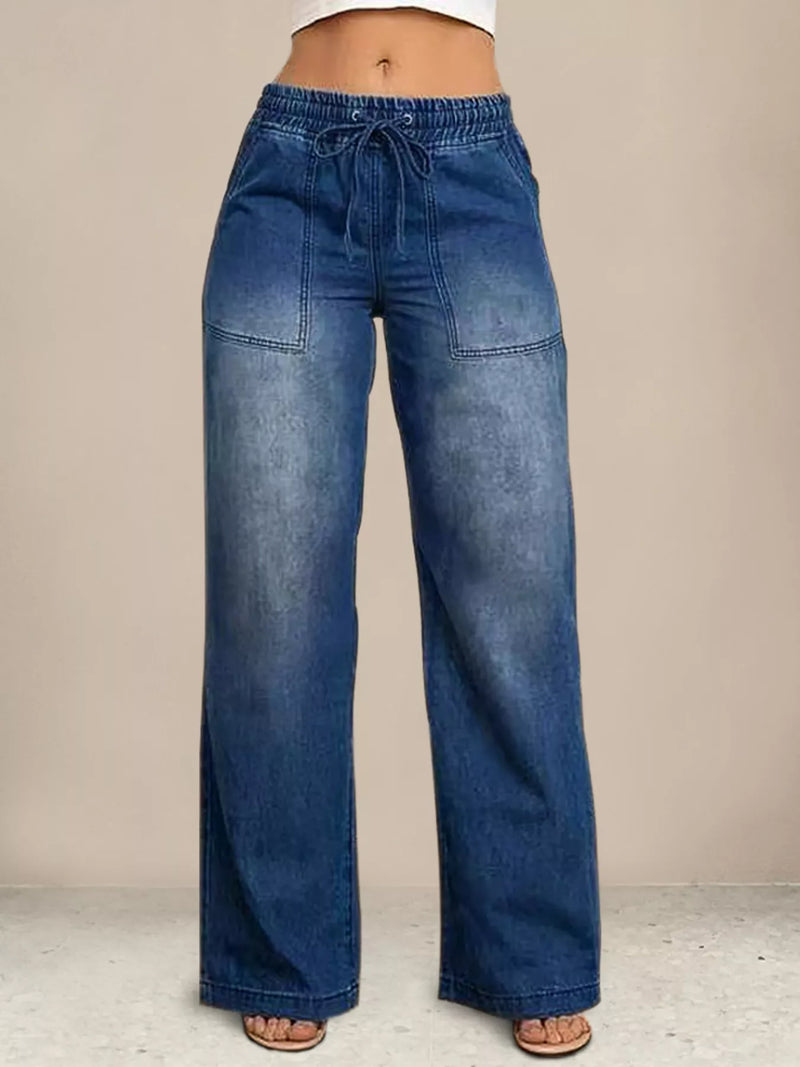 Blue wide-leg jeans on a neutral background