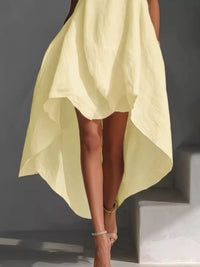 Person wearing a light yellow dress with a dark background