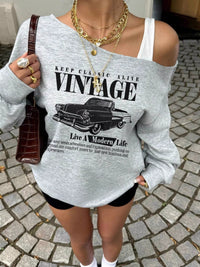 Person wearing a gray sweatshirt with vintage car graphic and text.