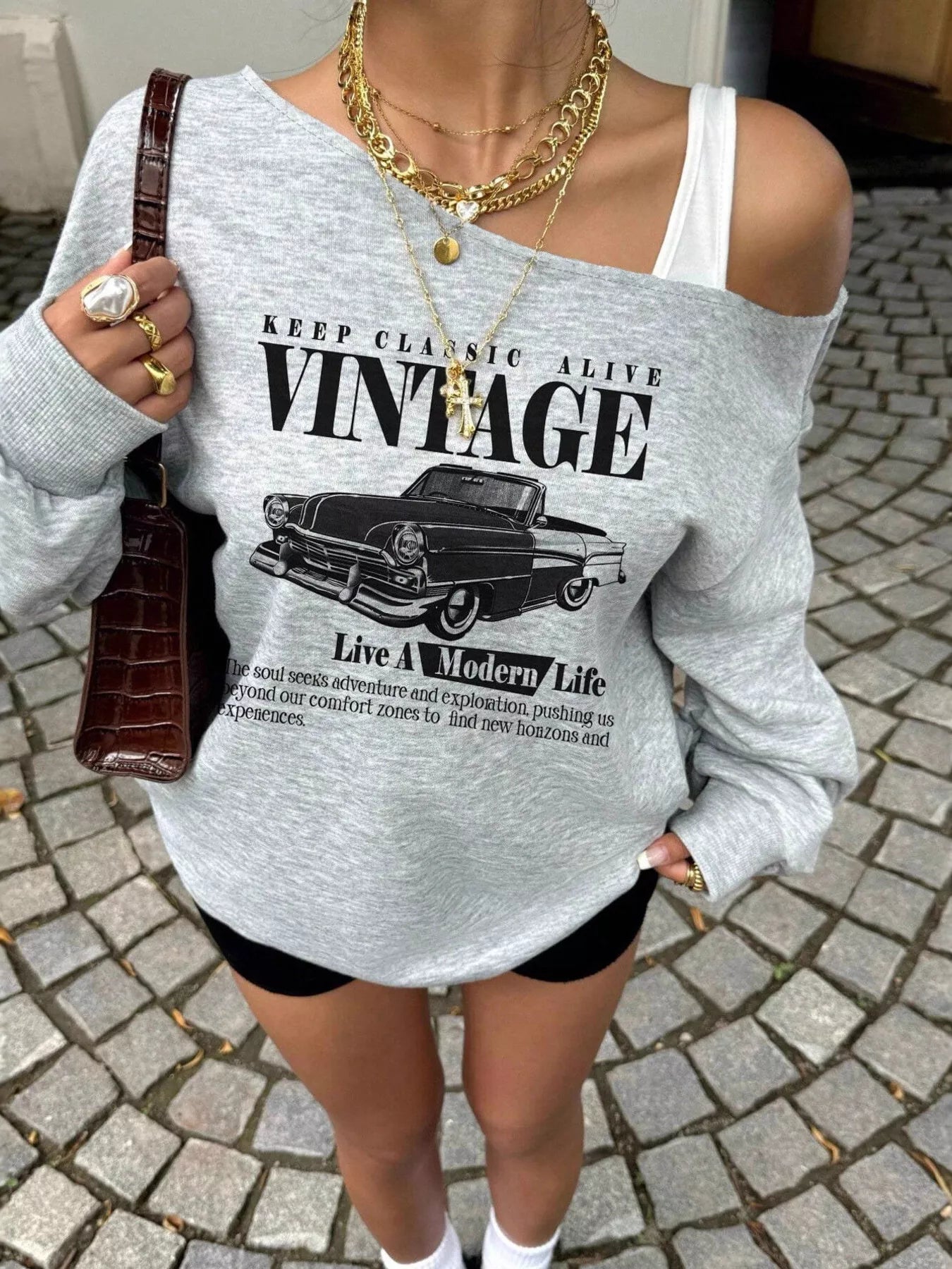 Person wearing a gray sweatshirt with vintage car graphic and text.