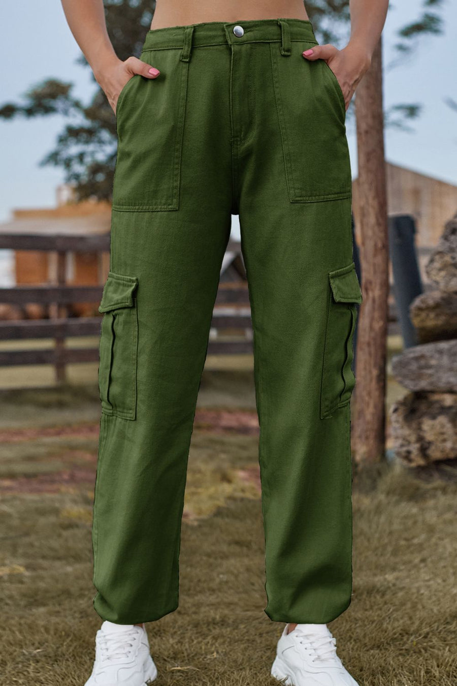 Person wearing green cargo pants with a blurred outdoor background