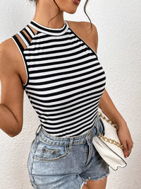 Person wearing a black and white striped tank top and denim shorts against a white background