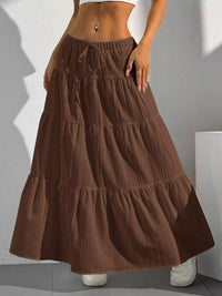 Brown tiered skirt worn by a person against a neutral background