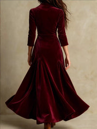 Burgundy velvet dress with a fitted bodice and flowing skirt on a neutral background
