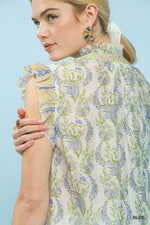 Woman wearing a floral blouse against a light blue background