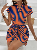 Woman wearing a blue and orange striped dress on a white background