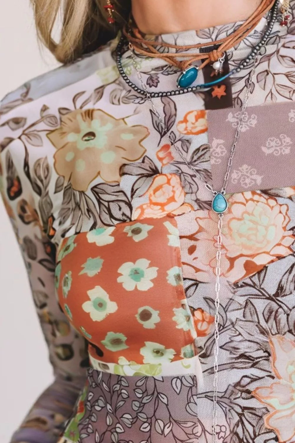 Close-up of a person wearing a floral-patterned top with a focus on the neckline and collar.