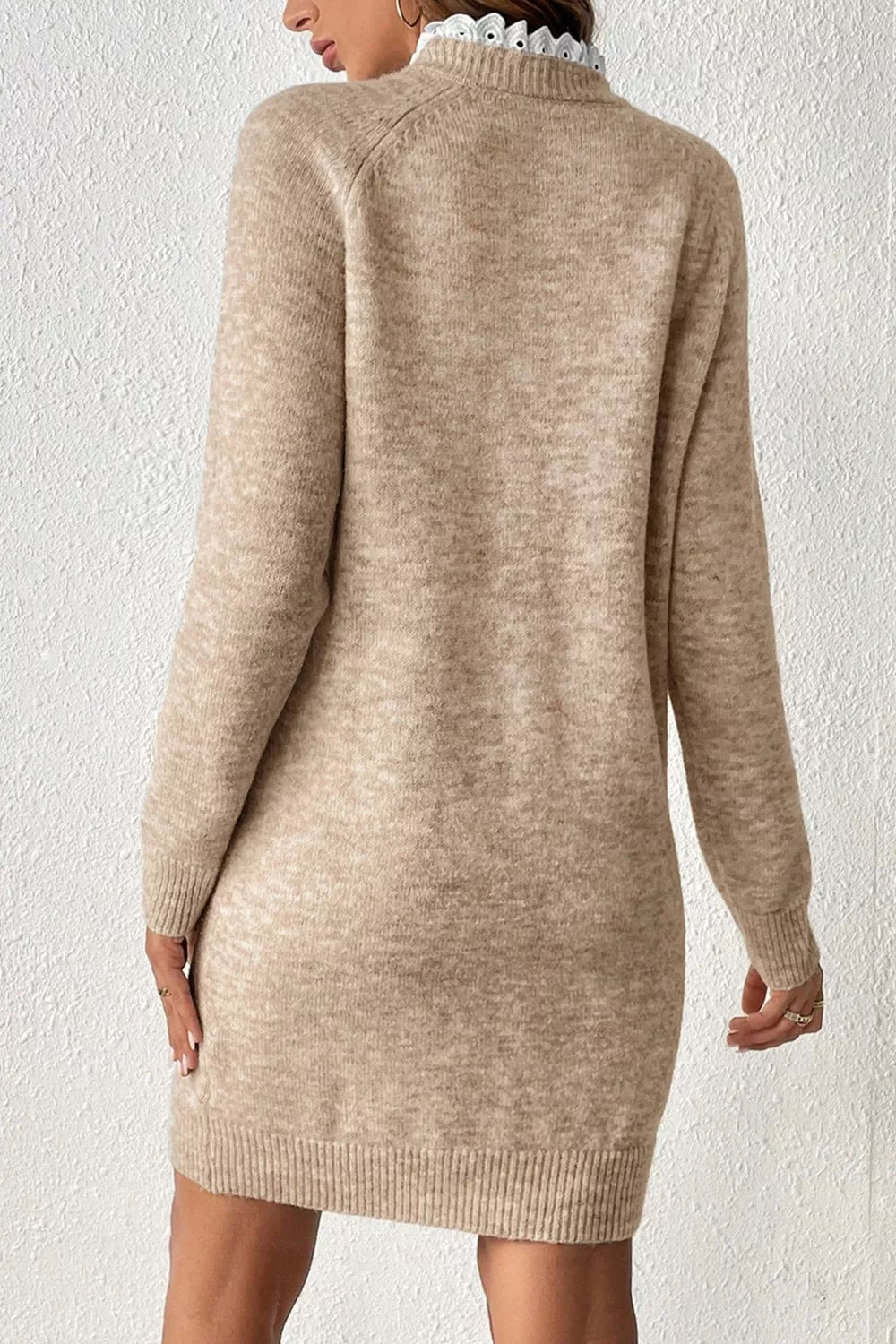 Beige sweater dress worn by a person on a white background