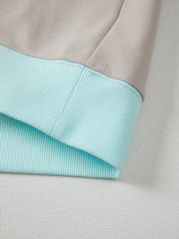 Close-up of a fabric with a light blue inner lining and gray outer layer.