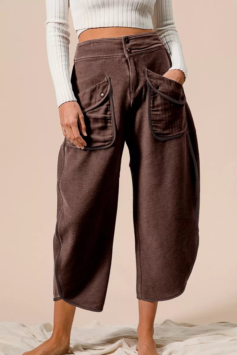 Brown wide-leg pants worn by a person on a beige background