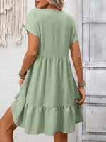 Green dress worn by a person against a light gray wooden panel background