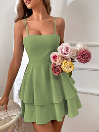Woman wearing a green dress holding a bouquet of flowers indoors.