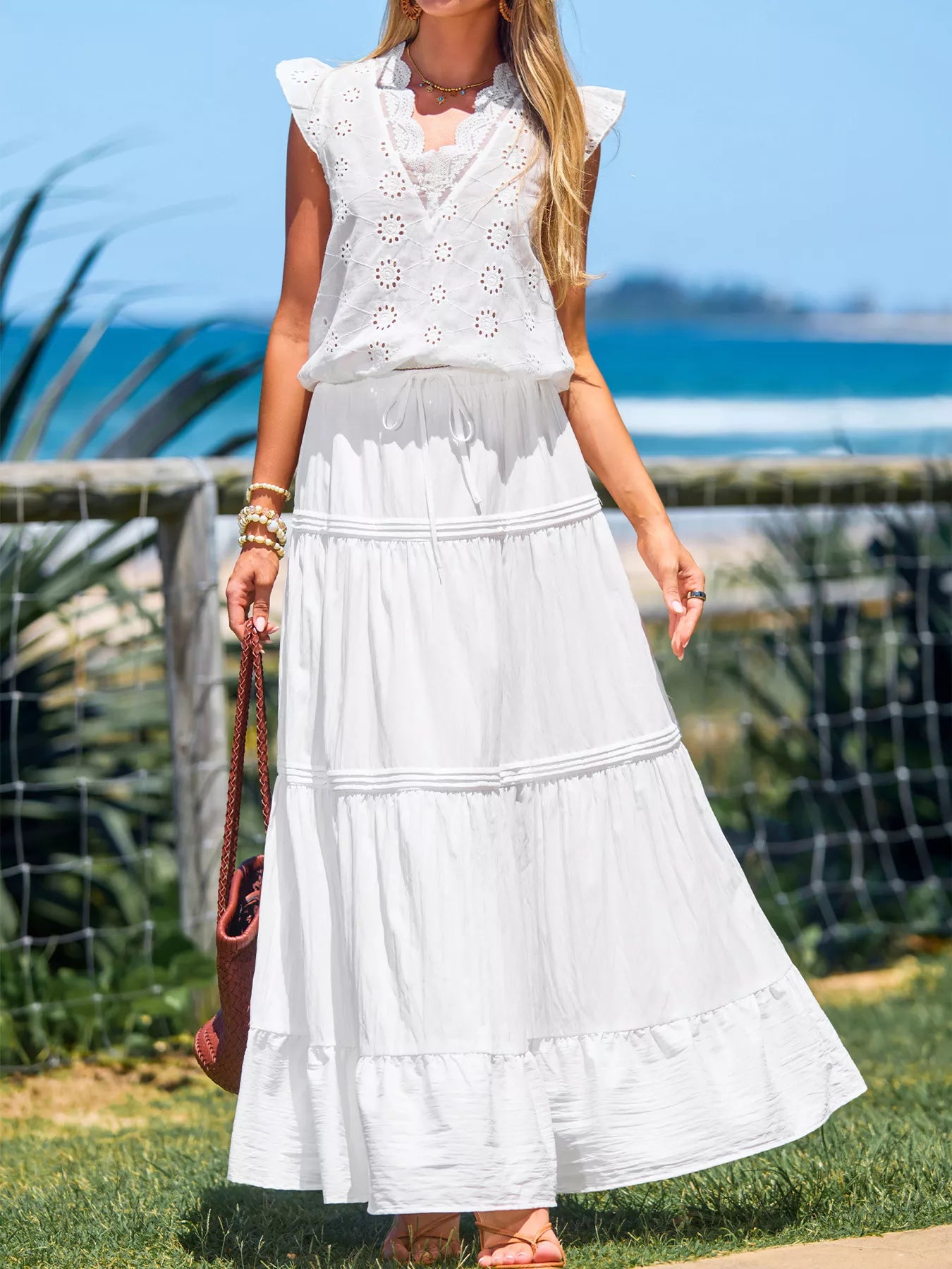 Woman wearing a white dress with a blurred beach background