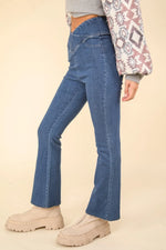 Person wearing blue jeans and beige shoes on a beige background