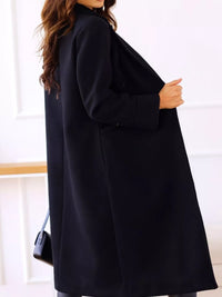 Person wearing a black coat with a blurred background
