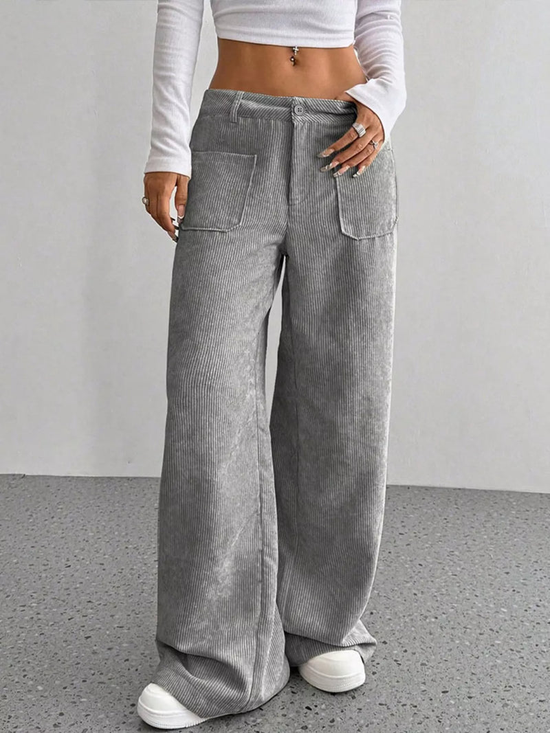 Person wearing gray wide-leg pants with a plain background