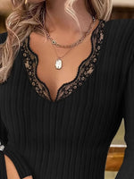 Close-up of a person wearing a black dress with lace detailing and a necklace.