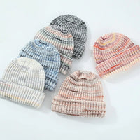 Set of colorful knit baby hats on a light background