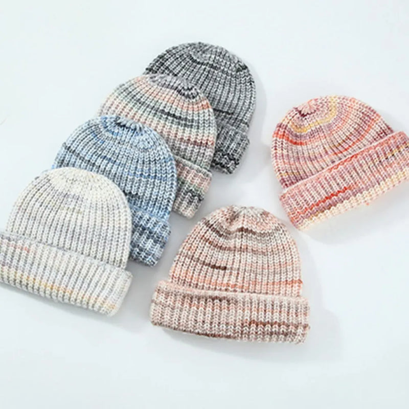 Set of colorful knit baby hats on a light background
