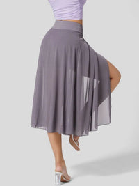 Person wearing a gray skirt with a sheer overlay on a white background