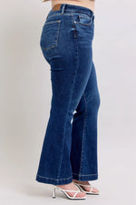 Blue jeans worn by a person on a plain background