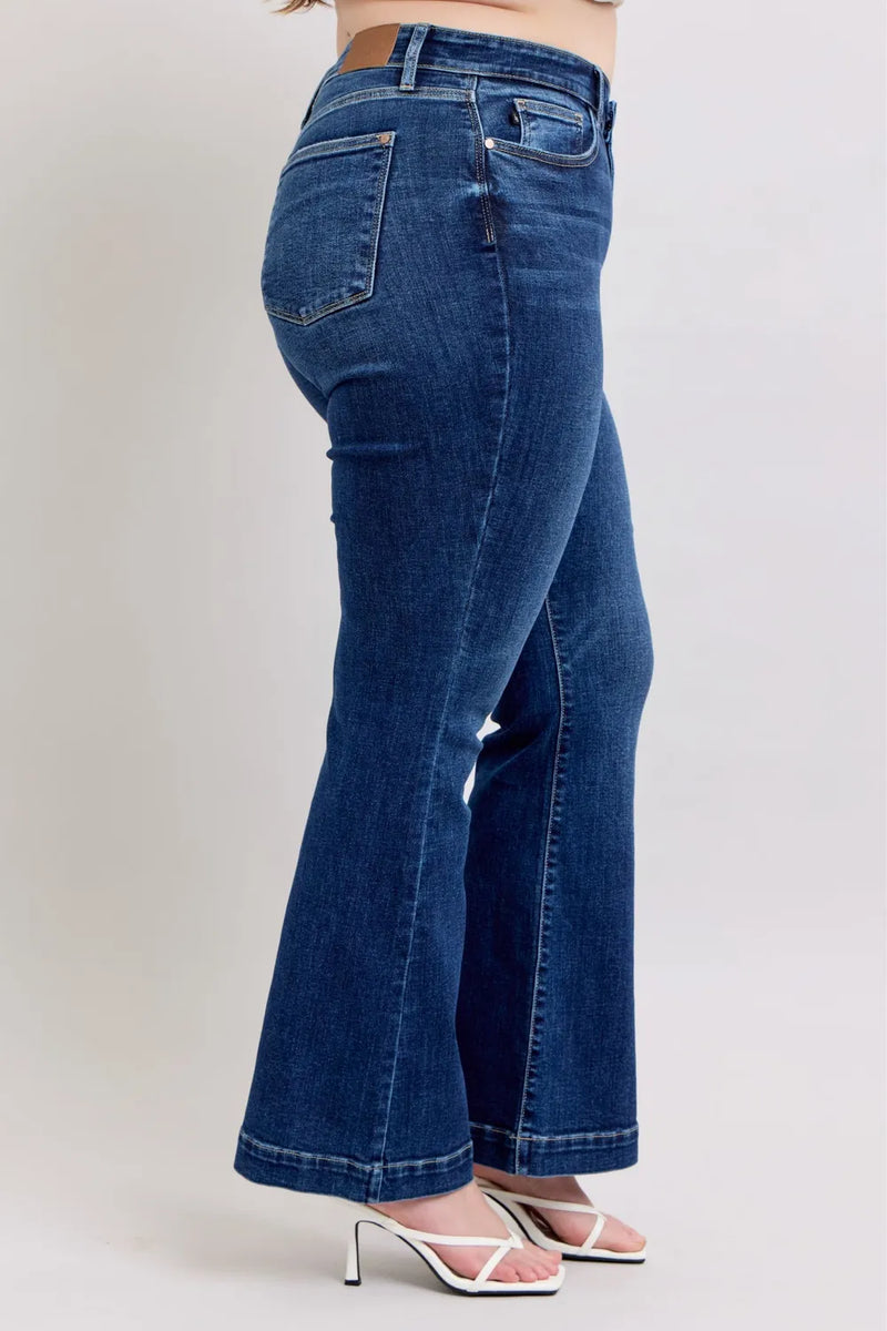 Blue jeans worn by a person on a plain background