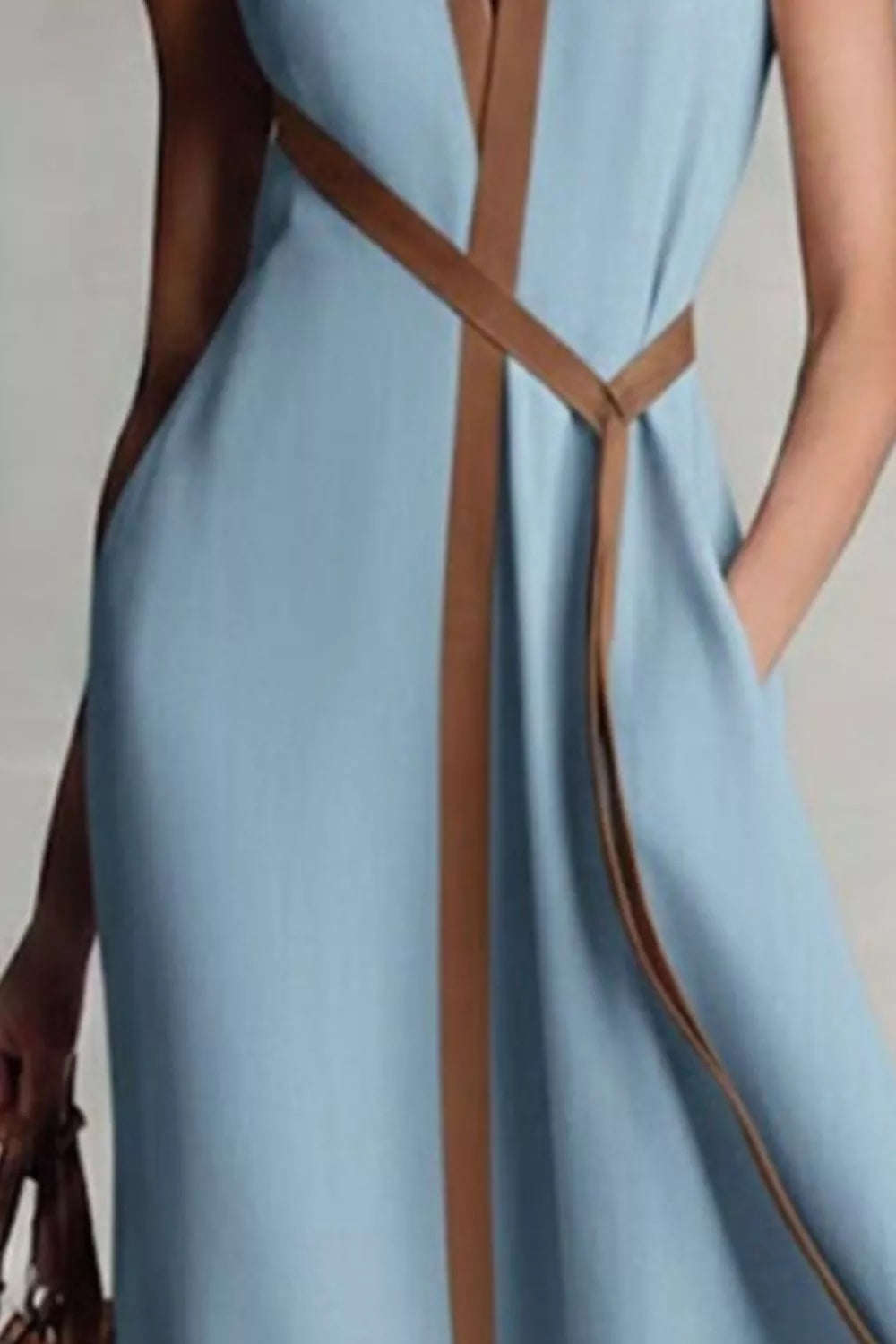 Light blue dress with brown straps on a plain background